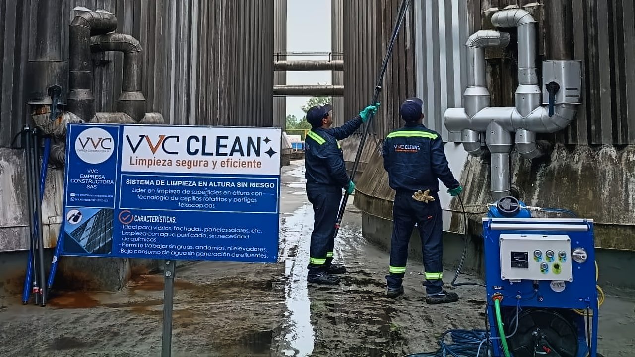 Equipo de VVC Clean en obra: cartel institucional, dos operarios con pértiga y el carro de agua purificada.